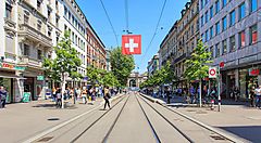 Una strada cittadina in Svizzera con bandiera svizzera appesa in alto.