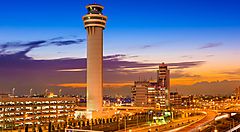 Torre di controllo e edifici aeroportuali al tramonto.