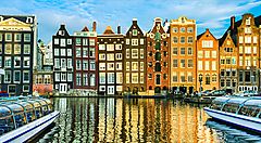 Edifici storici e canali riflessi nell'acqua ad Amsterdam.