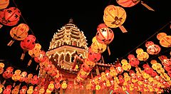 Lanterns illuminate a pagoda at night during a festival in Malaysia.