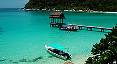 Spiaggia tropicale alle Isole Perhentian con mare turchese e barca.