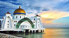 La moschea Masjid Selat sulle acque al tramonto.