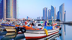 Barche nel porto con grattacieli sullo sfondo a Busan.