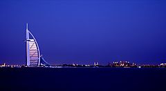 Lo skyline di Dubai illuminato al tramonto con il Burj Al Arab.