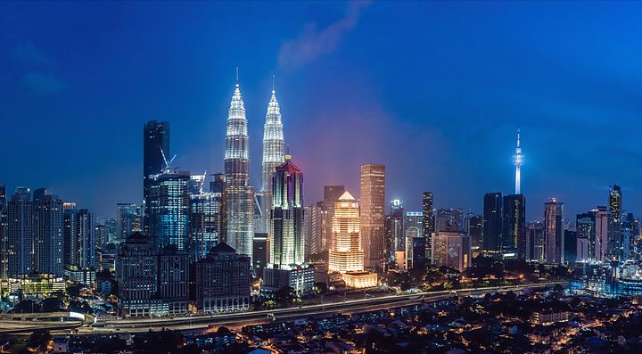 Skyline notturno di Kuala Lumpur con le Petronas Towers illuminate.