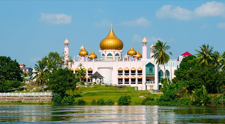 Moschea con cupole dorate in Malesia circondata dal verde.