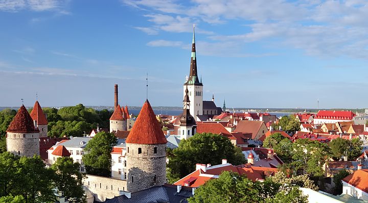 Paesaggio di Tallinn in Estonia con torri medievali e chiese sotto un cielo azzurro.