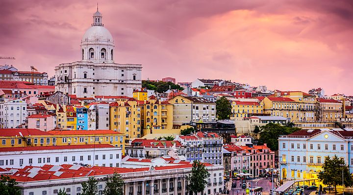 Veduta su Lisbona con edifici colorati e cielo al tramonto.