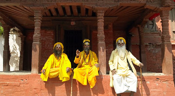 Tre uomini in abiti tradizionali davanti a un tempio in Nepal.
