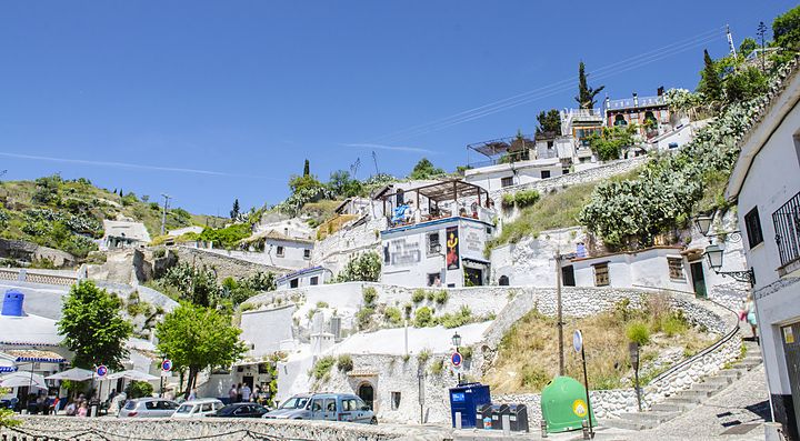 Case tradizionali sulla collina di Granada sotto un cielo azzurro.