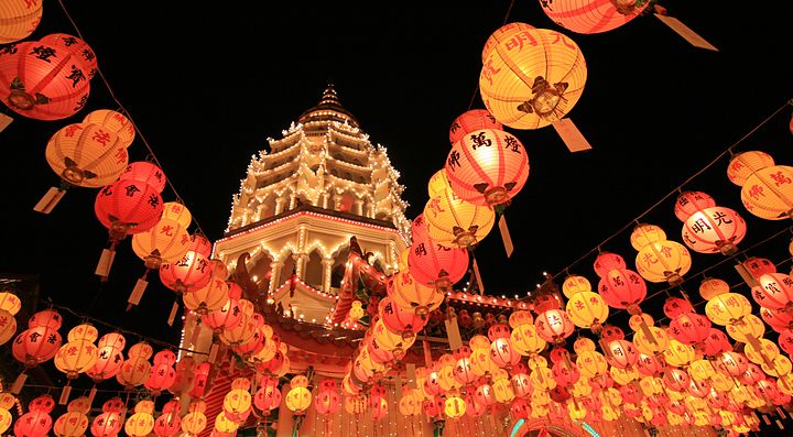 Lanterns illuminate a pagoda at night during a festival in Malaysia.