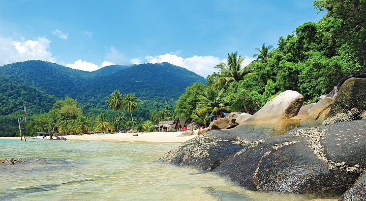 Spiaggia tropicale con palme e rocce sull'isola di Tioman.