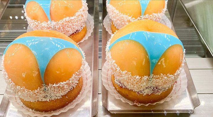 Dolci decorati a forma di fondoschiena con bikini blu, cosparsi di cocco.