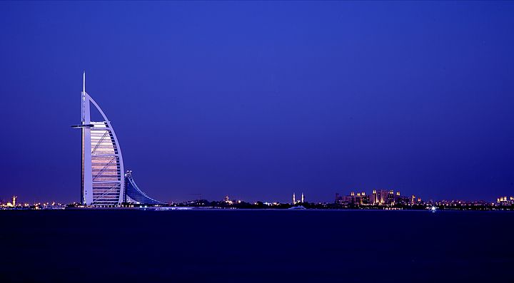 Lo skyline di Dubai illuminato al tramonto con il Burj Al Arab.