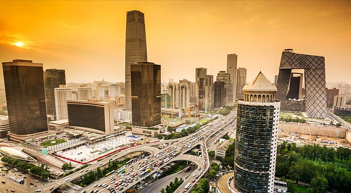 Skyline di Pechino al tramonto con edifici moderni e traffico stradale.