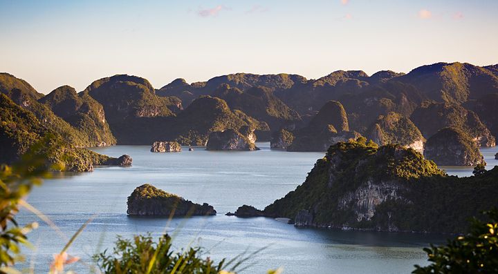 Baia di Ha Long in Vietnam con isolotti e mare al tramonto.
