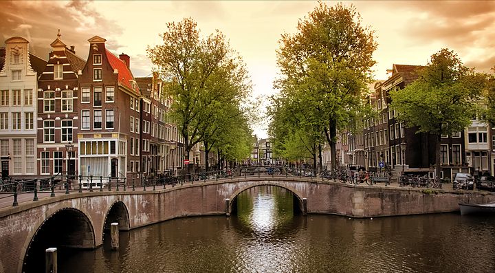 Tramonto su un canale con ponte ad Amsterdam.