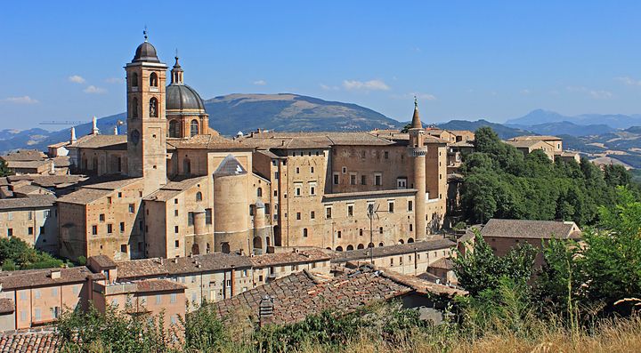 Veduta del Palazzo Ducale di Urbino circondato da colline.