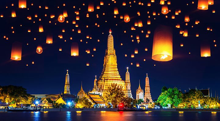 Lanterne che illuminano il cielo notturno sopra un tempio a Chiang Mai.