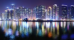 Grattacieli illuminati lungo la costa di Busan di notte.