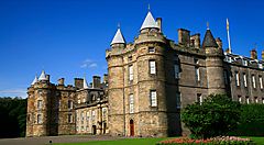 Il Palazzo di Holyroodhouse a Edimburgo sotto un cielo blu.