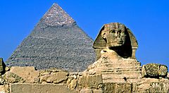 La Sfinge e una piramide in Egitto sotto un cielo azzurro.