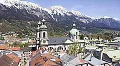 Innsbruck con le Alpi innevate sullo sfondo e tetti della città in primo piano.