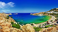 Baia di Rodi con acque turchesi e spiaggia affollata.