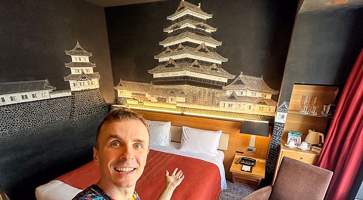 Interno di una stanza del Park Hotel Tokyo con decorazioni murali e Marco Togni.