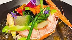 Piatto gourmet al ristorante Narisawa con decorazioni floreali e verdure.