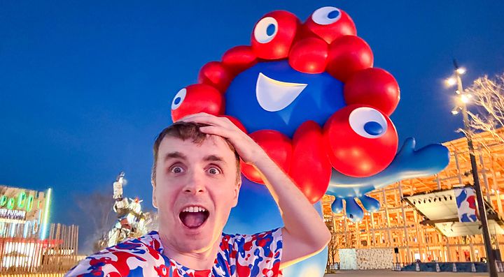 Marco Togni sorride davanti a Myaku-Myaku, mascotte di Expo 2025.