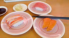 Piattini con sushi, in un ristorante di kaiten sushi.