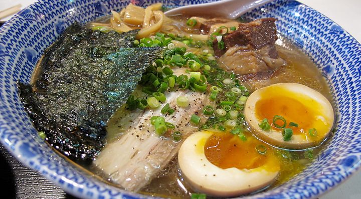 Ramen con brodo denso, pezzi di carne e uovo.