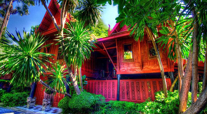 La casa di Jim Thomspon, rossa intorno ad una fitta vegetazione verde.