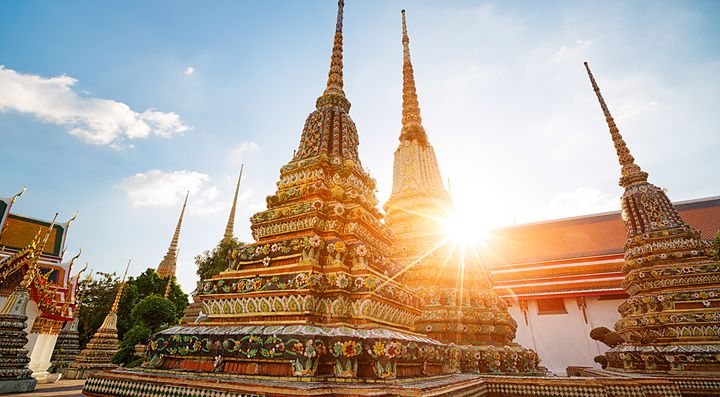 Stupa adornati al tramonto nel tempio Wat Pho a Bangkok.