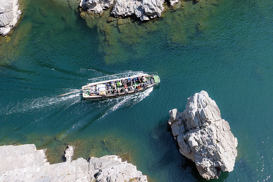 Veduta dall'alto di una barca turistica che solca le acque turchesi della gola di Oboke in Giappone.