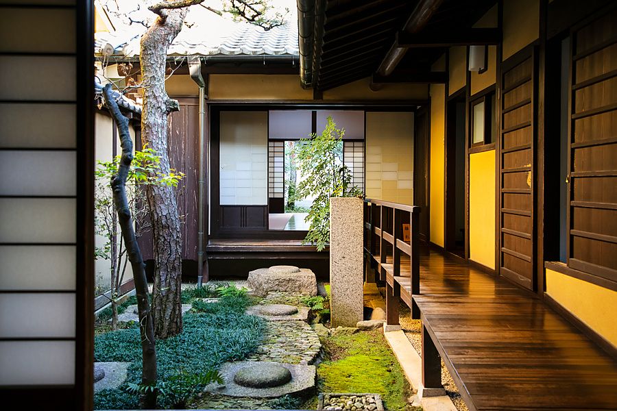 Veduta del cortile interno in una casa tradizionale giapponese a Nara con corridoio in legno e pietre.