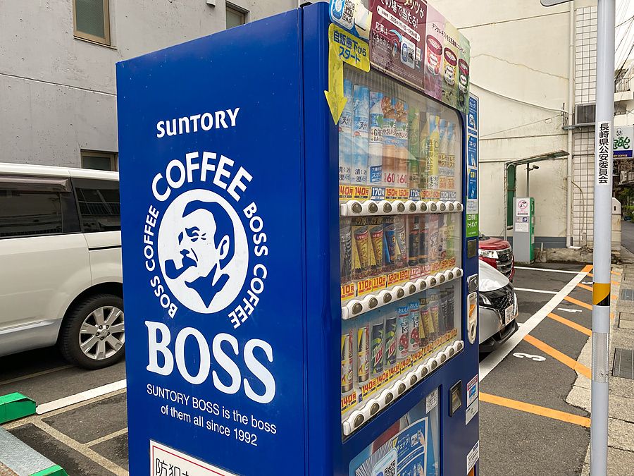 Distributore automatico di bevande Suntory Boss blu in un parcheggio all'aperto a Nagasaki.