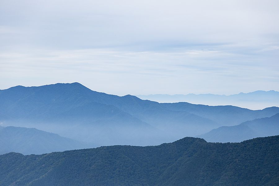 Veduta panoramica di catene montuose in Giappone che degradano in strati di colore blu verso l'orizzonte.