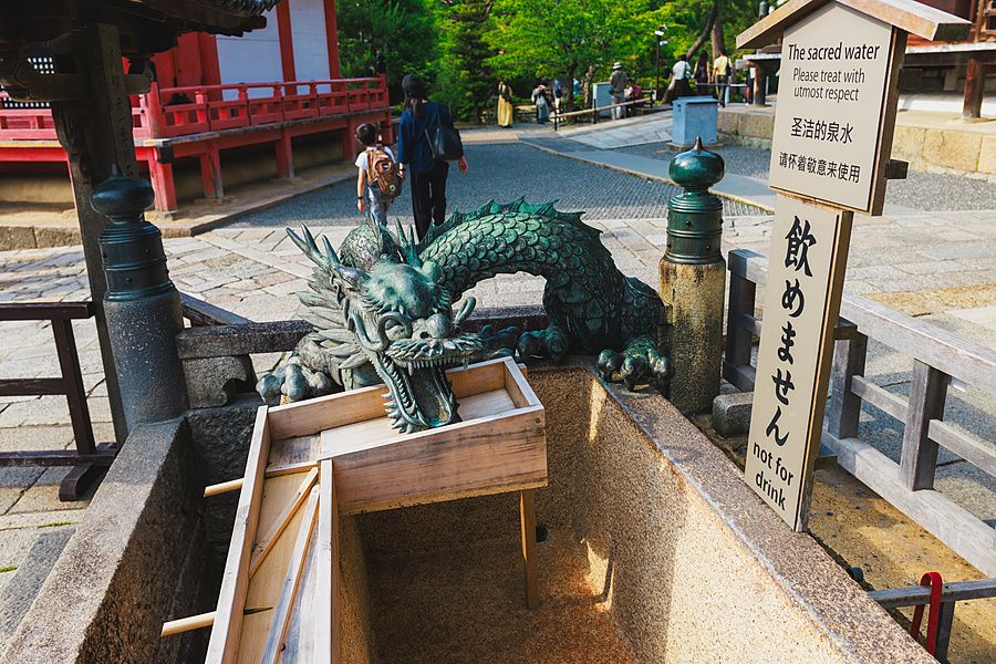 Fontana a forma di drago in bronzo con insegna informativa presso il tempio Kiyomizu-dera a Kyoto.