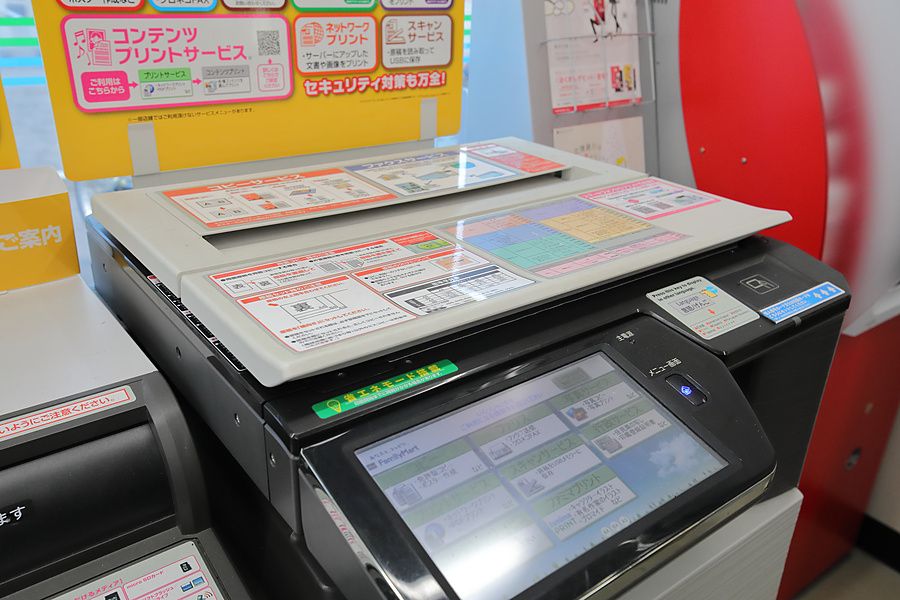Fotocopiatrice multifunzione in un minimarket giapponese con istruzioni operative e schermo touch.