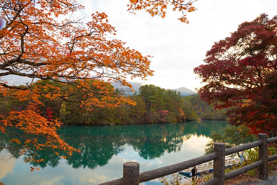 Veduta autunnale di Bishamon-numa con alberi colorati che si riflettono nelle acque del lago.