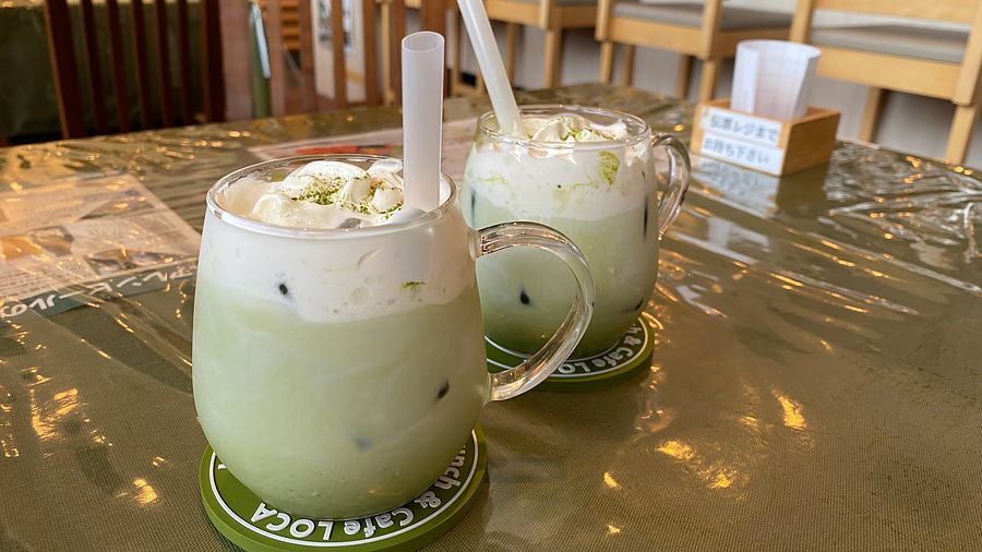 Due tazze trasparenti di matcha latte con panna montata su un tavolo in un caffè a Nara, Giappone.
