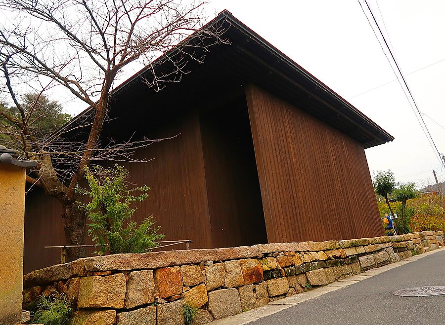 Edificio in legno scuro con basamento in pietra a Naoshima in Giappone.