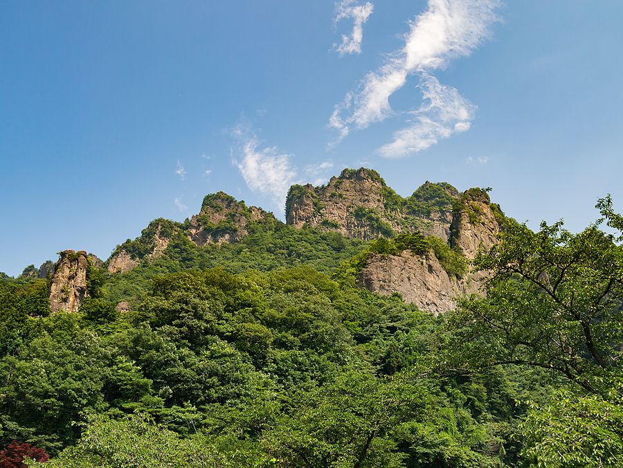 Veduta panoramica del Monte Myogi in Giappone con pareti rocciose, picchi frastagliati e una lussureggiante vegetazione.