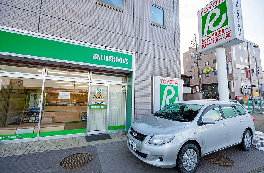 Centro di noleggio auto Toyota con un'auto parcheggiata davanti in una giornata invernale in Giappone.