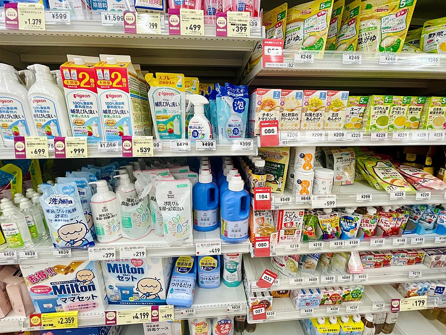Scaffali di un negozio in Giappone con vari prodotti per la cura e l'alimentazione dei neonati esposti in vendita.