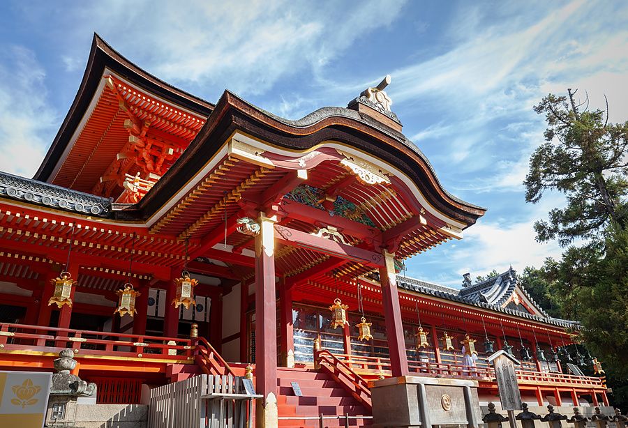 Veduta dal basso del santuario principale di Iwashimizu Hachimangu a Kyoto con dettagli architettonici rossi.