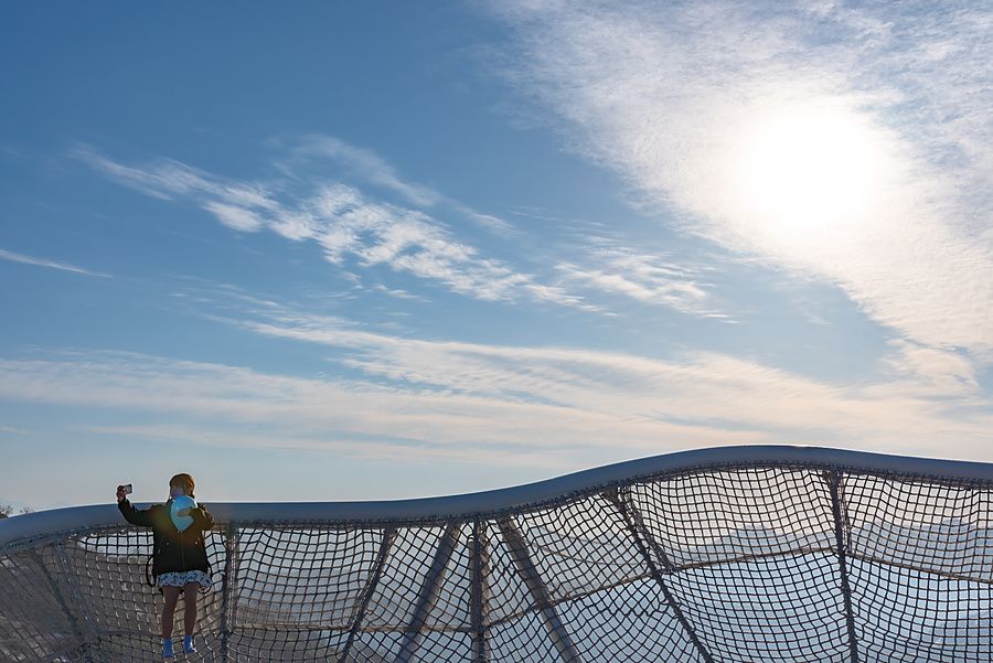 Persona che scatta un selfie sulla piattaforma panoramica di Unkai Terrace con cielo blu.