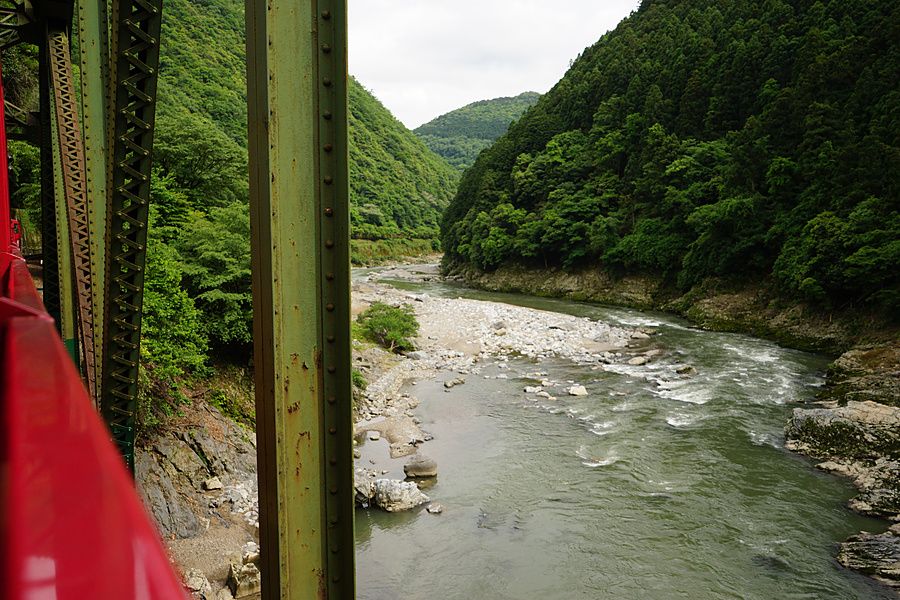 Vista dal treno panoramico Sagano sul fiume Hozu e sulle montagne boscose di Arashiyama, Giappone.
